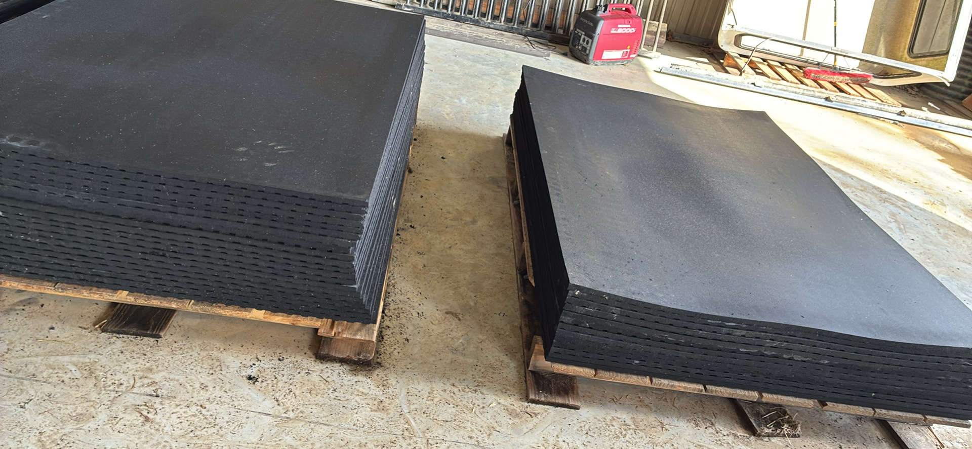 Stacked rubber mats on pallets ready for delivery